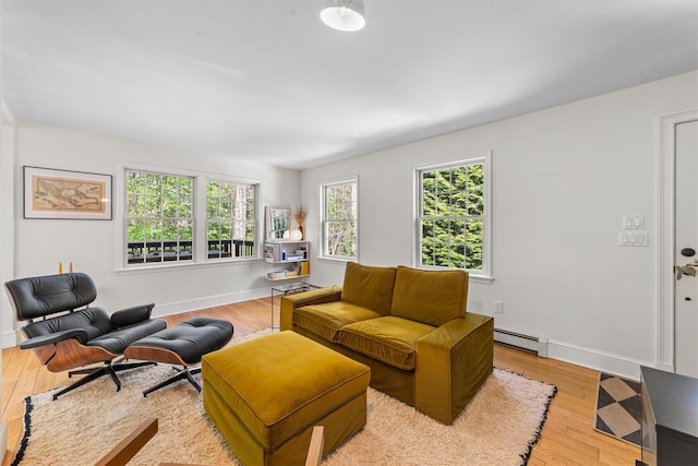 living area featuring baseboards, baseboard heating, and hardwood / wood-style floors
