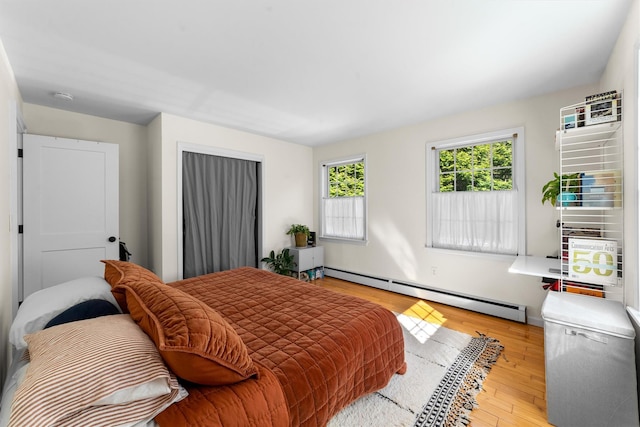 bedroom featuring baseboard heating and wood finished floors