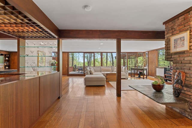 living room with beam ceiling and light wood-style flooring