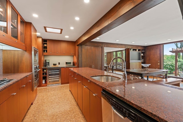 kitchen featuring a sink, dark stone counters, recessed lighting, beverage cooler, and appliances with stainless steel finishes