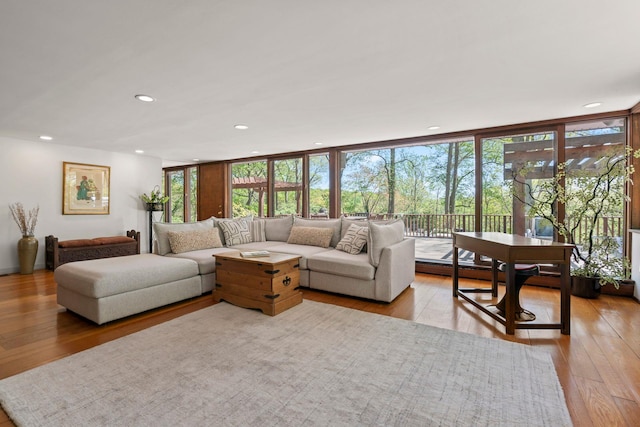 living area featuring a wealth of natural light, hardwood / wood-style floors, and expansive windows