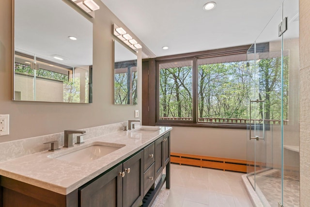 bathroom with a sink, a baseboard radiator, double vanity, and a stall shower