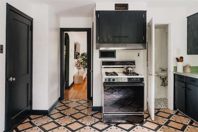 2383 State Route 97, Pond Eddy, NY 12770 - kitchen featuring gas range oven, inlaid floor details, and dark cabinetry