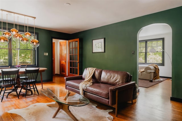 2383 State Route 97, Pond Eddy, NY 12770 - living room featuring arched walkways, wood finished floors, a chandelier, and baseboards