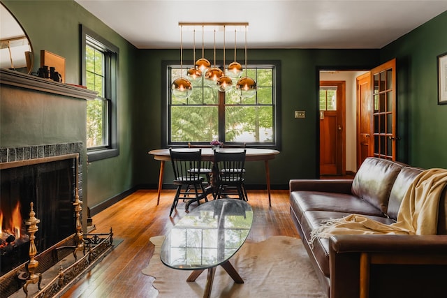 2383 State Route 97, Pond Eddy, NY 12770 - living area featuring a fireplace with flush hearth, hardwood / wood-style flooring, a chandelier, and baseboards