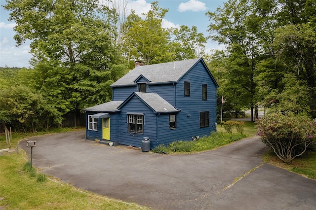 2383 State Route 97, Pond Eddy, NY 12770 - rustic home featuring a chimney, a shingled roof, driveway, and view of wooded area