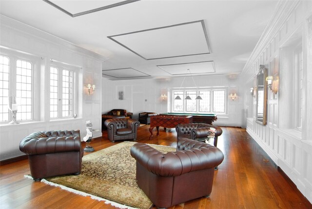 living room with billiards, a wealth of natural light, attic access, and wood finished floors