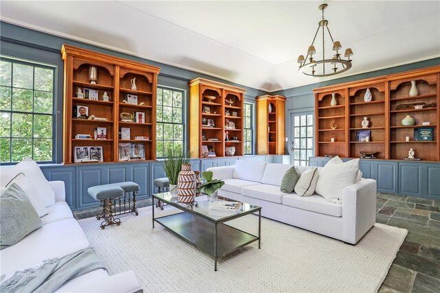living room featuring stone finish flooring and a notable chandelier