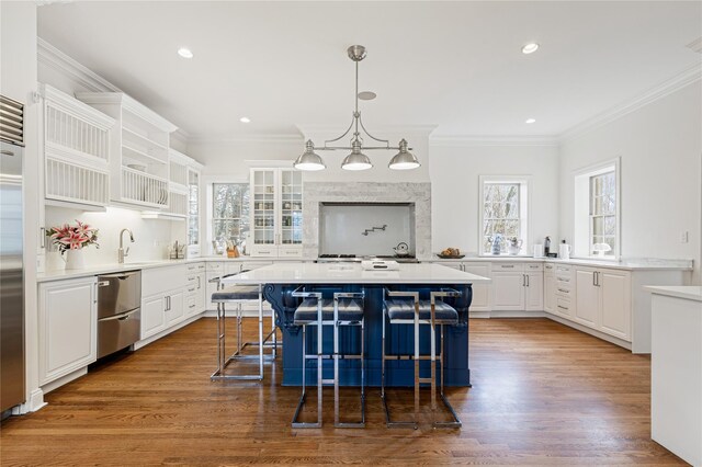 kitchen featuring a kitchen island, white cabinets, ornamental molding, and dishwasher