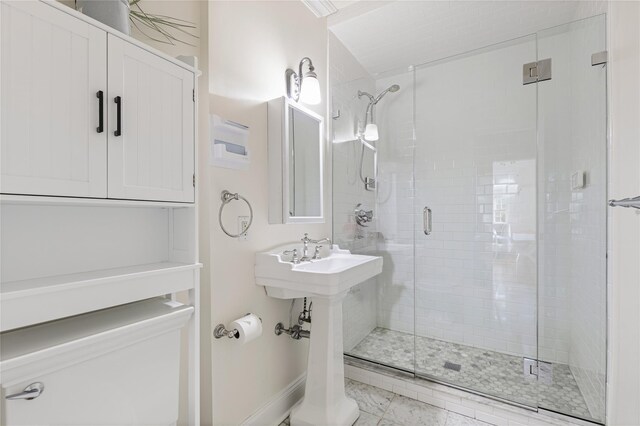 full bathroom featuring baseboards and a shower stall