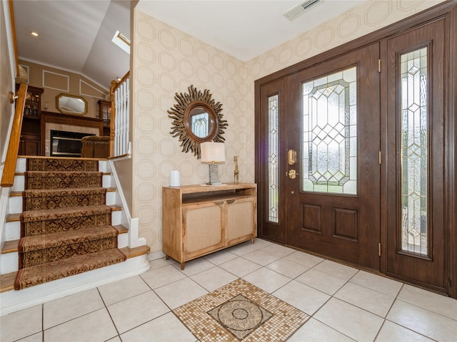 entryway with lofted ceiling, stairs, light tile patterned flooring, visible vents, and wallpapered walls