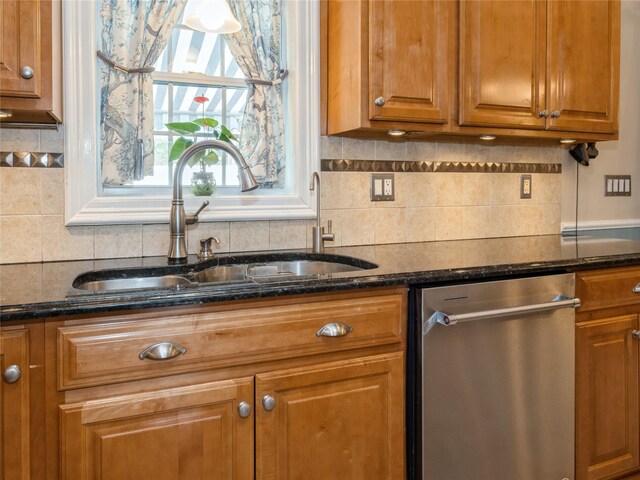 kitchen featuring dishwasher, decorative backsplash, brown cabinetry, and a sink