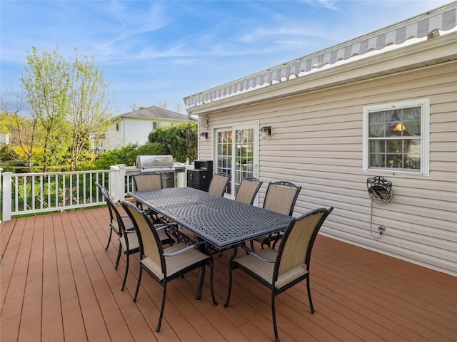 deck featuring a grill and outdoor dining area