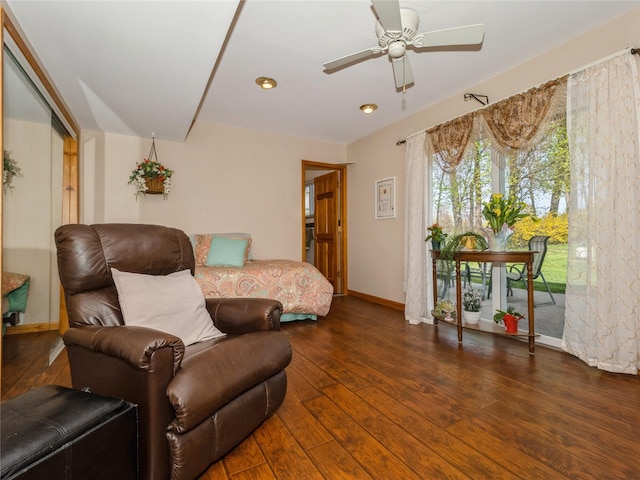 interior space with a ceiling fan, baseboards, and wood finished floors