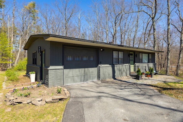 mid-century inspired home with an attached garage, brick siding, and driveway