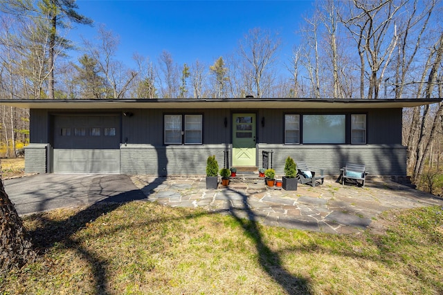 ranch-style home featuring an attached garage, driveway, and entry steps
