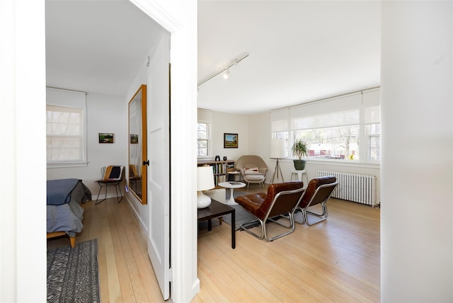 interior space featuring radiator, rail lighting, and light wood-style flooring