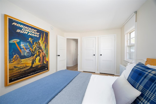 bedroom with wood finished floors, a closet, and baseboards