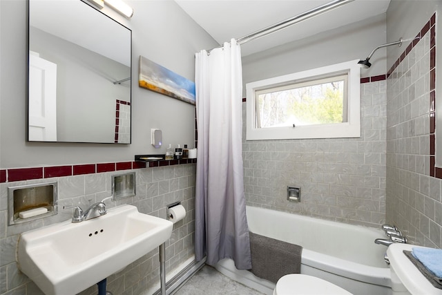 bathroom featuring shower / tub combo, tile walls, a sink, and toilet