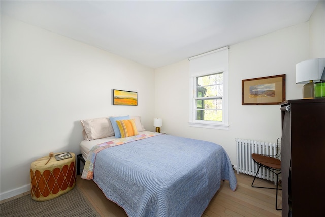 bedroom with wood finished floors and radiator