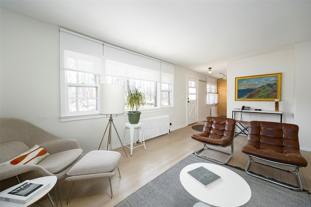 living area with baseboards, radiator heating unit, and wood finished floors