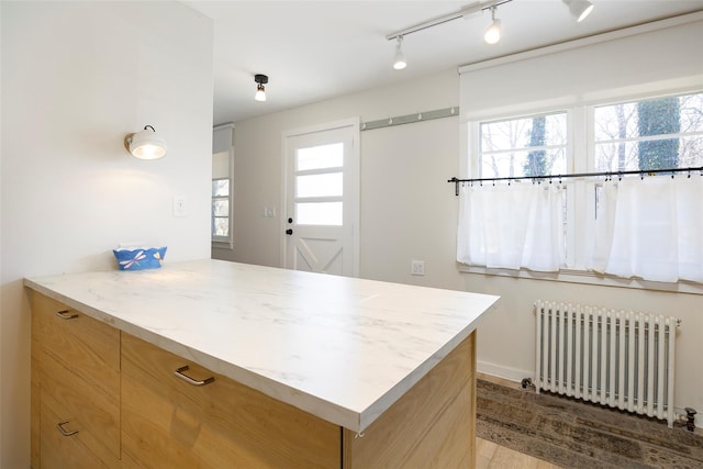 kitchen featuring radiator, light brown cabinetry, track lighting, modern cabinets, and a peninsula