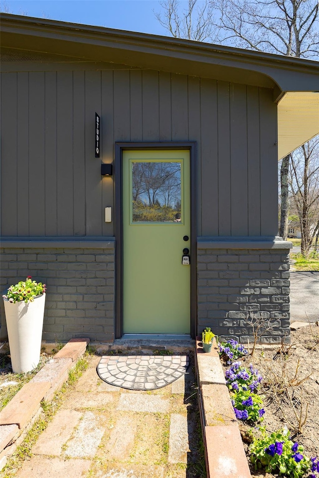 doorway to property featuring brick siding