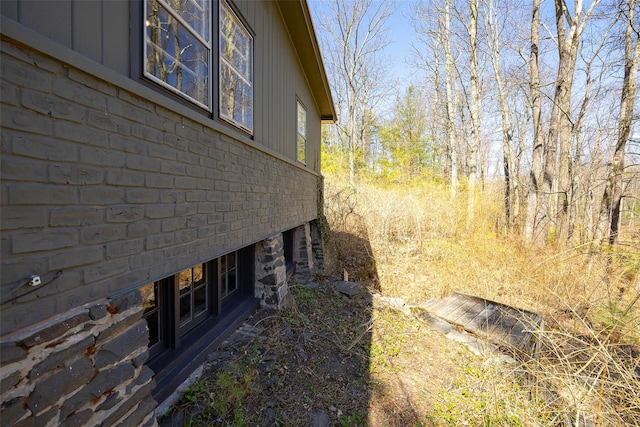 view of side of home featuring board and batten siding and brick siding