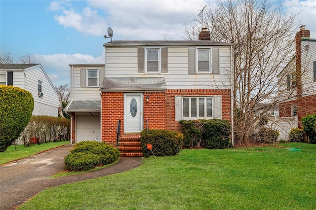 view of front of house with a front lawn, a chimney, brick siding, an attached garage, and aphalt driveway