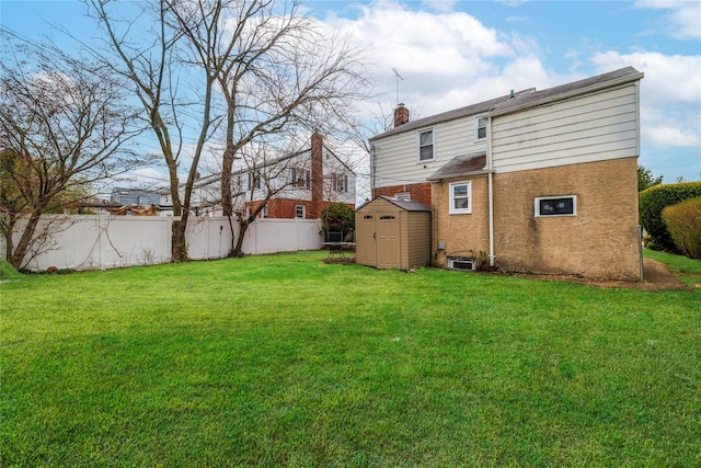 back of property with a storage shed, a lawn, a chimney, fence, and an outbuilding