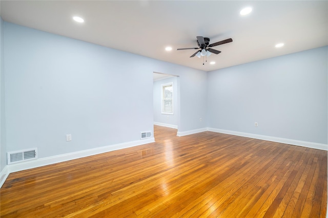 unfurnished room featuring hardwood / wood-style floors, visible vents, and ceiling fan