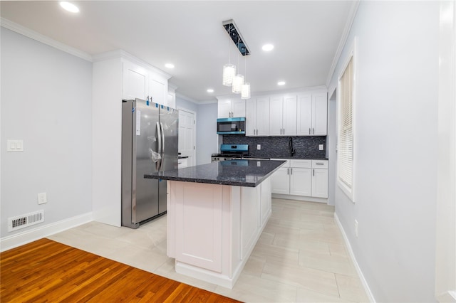 kitchen with white cabinets, visible vents, baseboards, tasteful backsplash, and appliances with stainless steel finishes