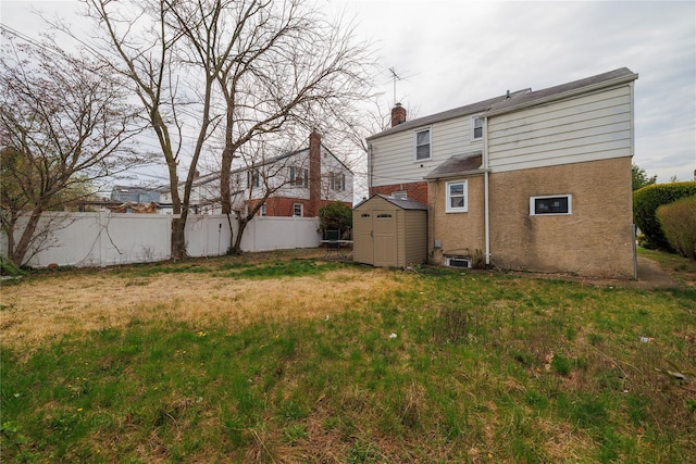 back of house with a storage shed, a chimney, fence, an outdoor structure, and stucco siding