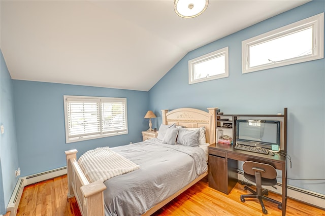 bedroom with a baseboard heating unit, multiple windows, vaulted ceiling, and wood finished floors