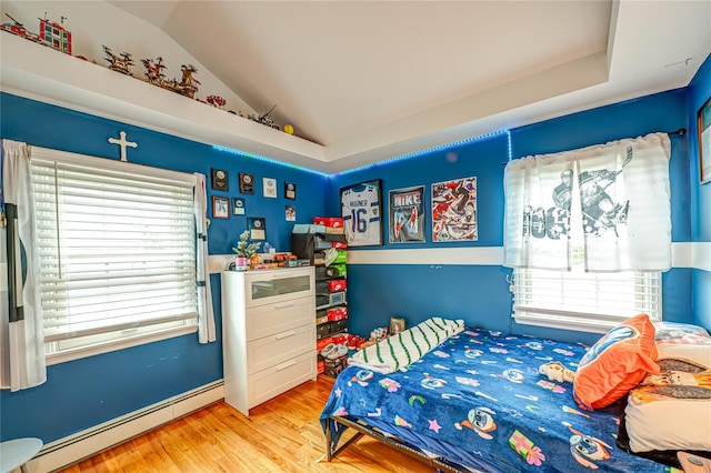 bedroom featuring vaulted ceiling, wood finished floors, and a baseboard radiator