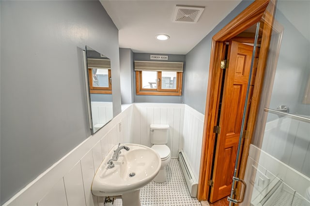 bathroom with a sink, toilet, visible vents, wainscoting, and baseboard heating