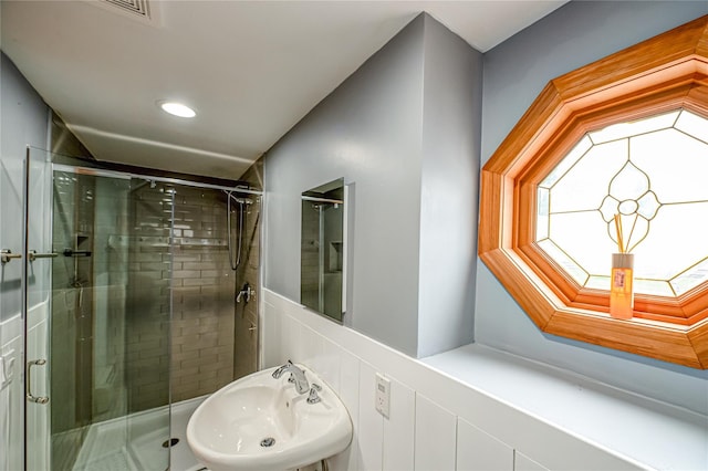 bathroom with recessed lighting, a sink, a shower stall, and visible vents