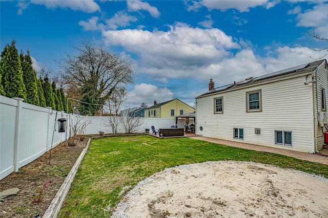 view of yard featuring a hot tub, a patio, and a fenced backyard