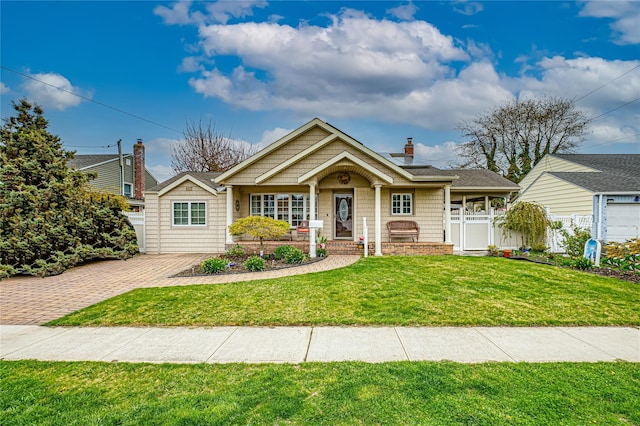view of front of home with a front yard, a chimney, covered porch, and fence