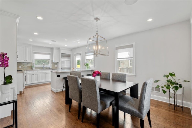 dining space featuring an inviting chandelier, wood finished floors, recessed lighting, and baseboards