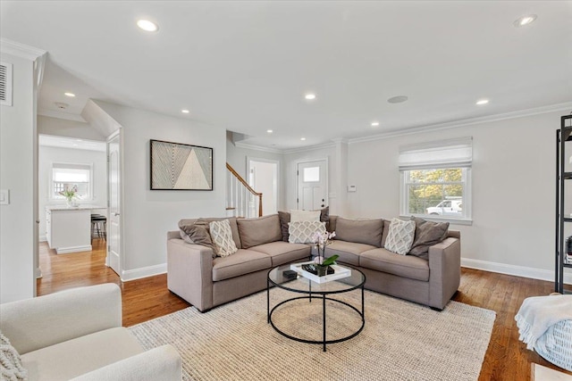 living room featuring recessed lighting, crown molding, and baseboards