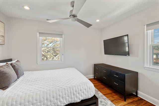 bedroom with a ceiling fan, baseboards, and dark wood-type flooring
