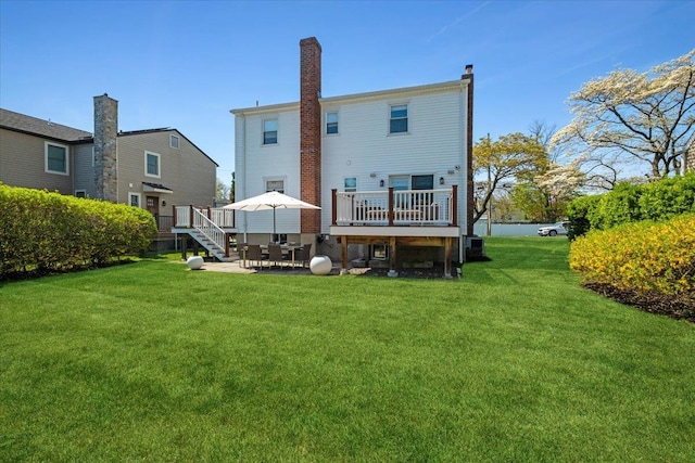 back of house featuring a lawn, a deck, and a patio