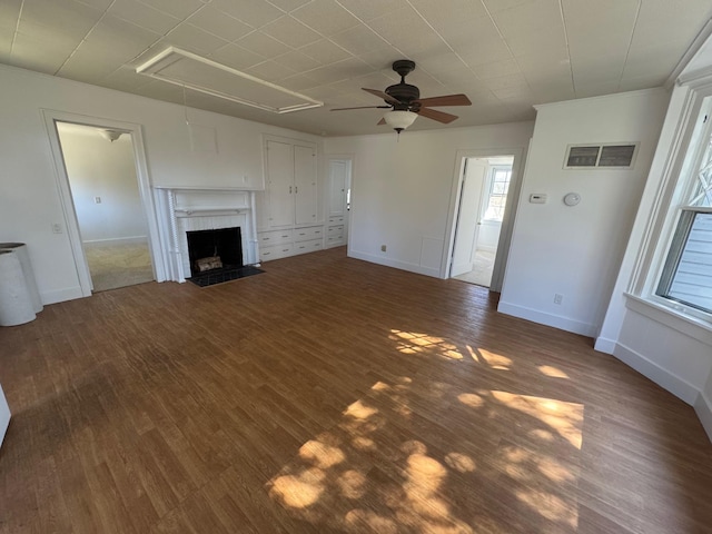 1845 Shipyard Ln, East Marion, NY 11939 - unfurnished living room featuring attic access, a ceiling fan, dark wood-style floors, baseboards, and a fireplace with flush hearth
