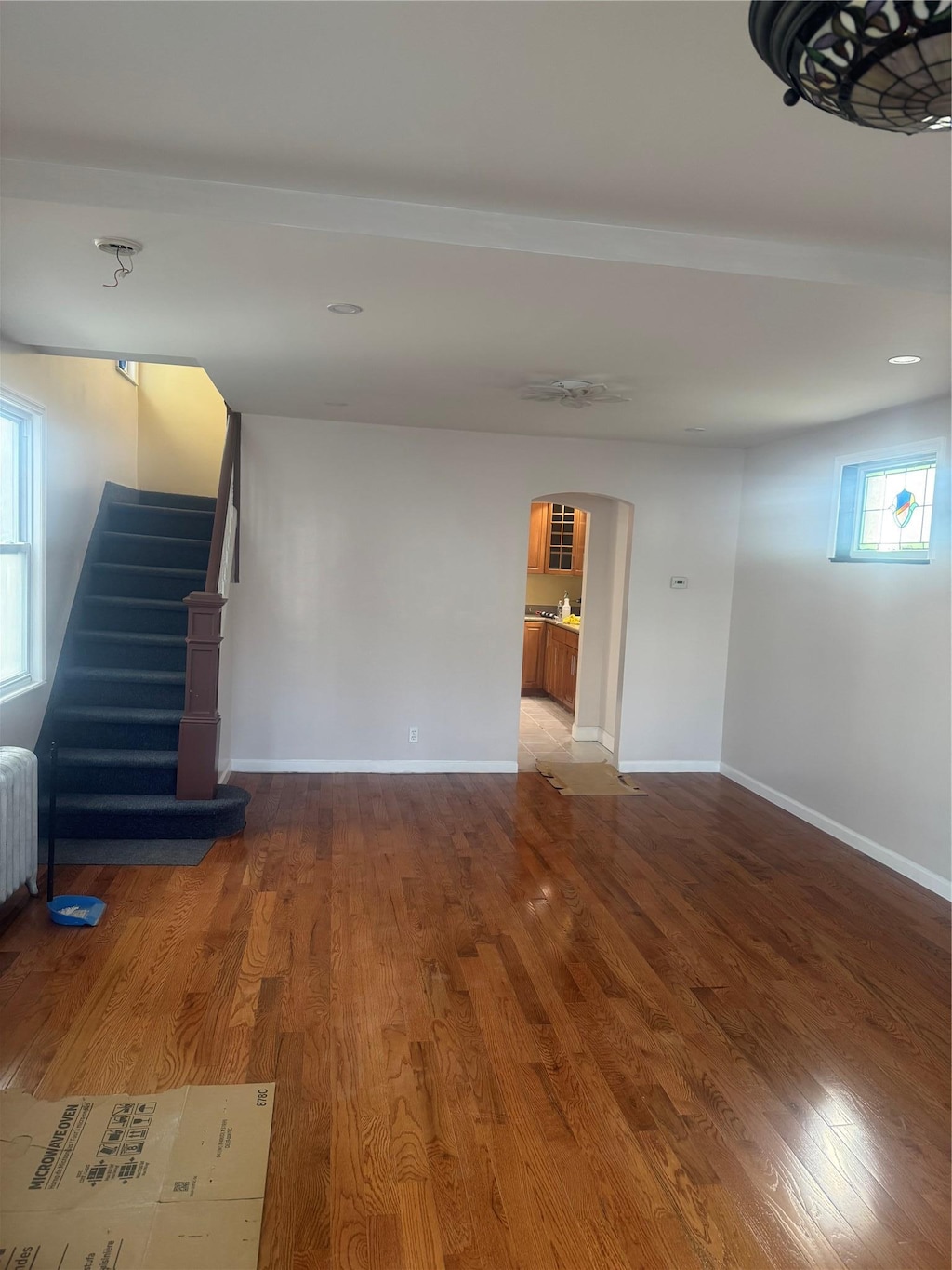 116-30 130th St, South Ozone Park, NY 11420 - unfurnished living room with arched walkways, wood finished floors, and baseboards