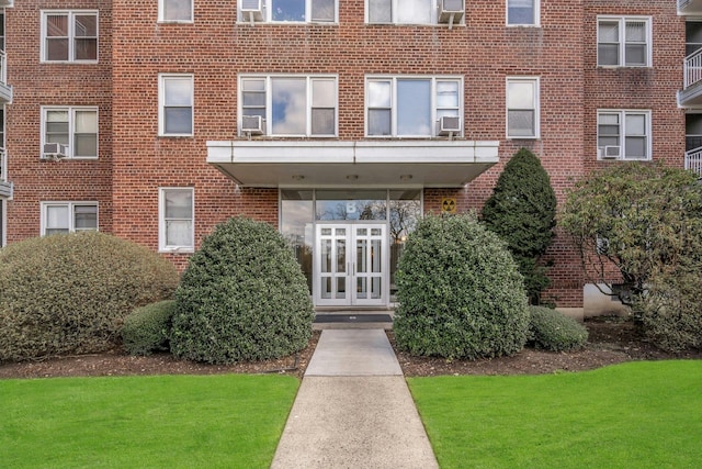 exterior space with a yard, french doors, and brick siding