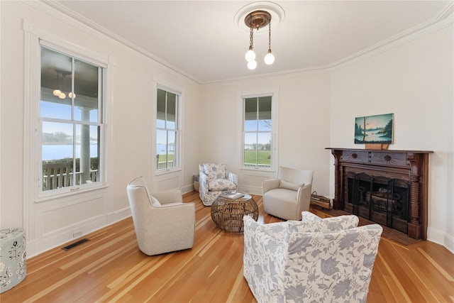 127 Senix Ave, Center Moriches, NY 11934 - living area featuring visible vents, light wood-style floors, crown molding, and a fireplace
