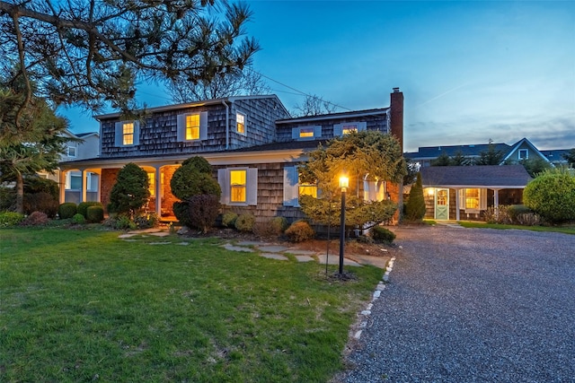 traditional home featuring a yard and a chimney