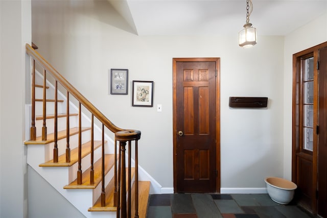 entrance foyer with stairs and baseboards