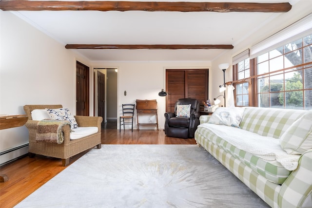 living room featuring ornamental molding, beam ceiling, and wood finished floors
